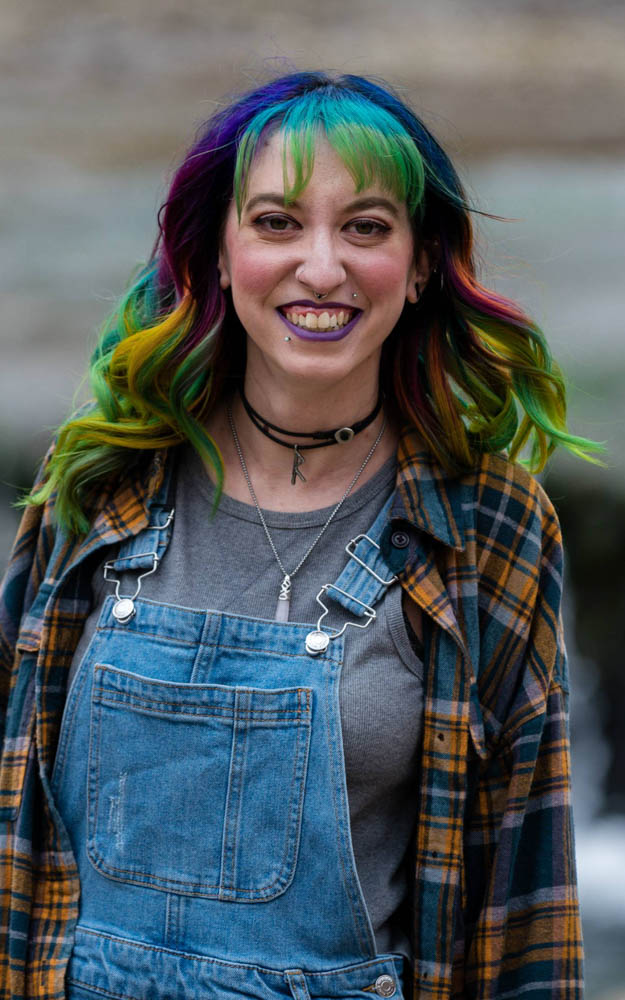 Sara standing in front of a waterfall during a photoshoot with her husband. Who happens to be a pretty awesome photographer! My hair is rainbow color. This was the first time I did rainbow colored hair!